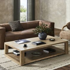 a living room with a couch, coffee table and two chairs in front of a window