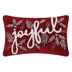 a red pillow with the word joy on it