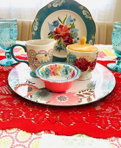 the table is set with dishes, cups and saucers