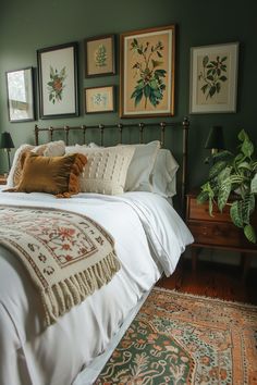 a bedroom with green walls and pictures on the wall above the bed, along with an area rug