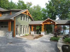 a couple of houses sitting next to each other on a gravel lot with trees in the background