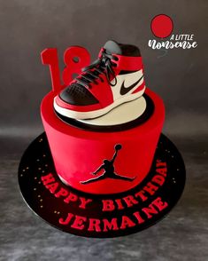 a red and black birthday cake with a shoe on top