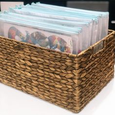 a basket filled with magazines on top of a white counter next to a computer keyboard