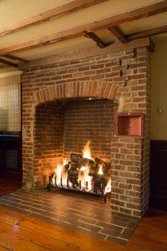 a brick fireplace with fire burning in it