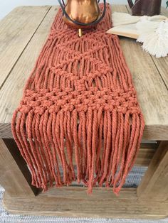 a wooden table topped with an orange scarf