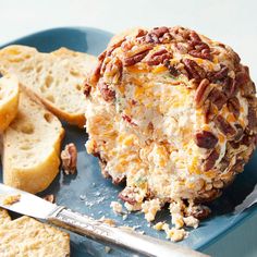 a blue plate topped with cheese and nuts next to crackers on top of it