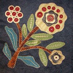 an embroidered piece with flowers and leaves on it