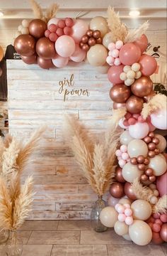 the balloon arch is decorated with pink, gold and white balloons that spell out girl power