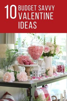 valentine's day table with pink flowers and candy in glass vases on it