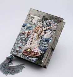 a book with an image of a woman on the cover and tassels around it