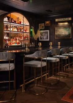 a dimly lit bar with several stools in front of it