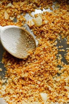 a wooden spoon with some food in it on a pan filled with other things to eat