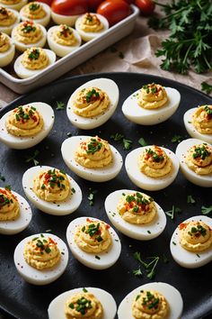 deviled eggs are arranged on a black plate