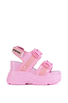 The Peach High Flatform Sneaker Sandal In Pink is a glossy hybrid style featuring a faux patent leather upper, a sneaker-inspired textured rubber flatform outsole, an open almond toe silhouette, a chunky wedge heel, a coordinating platform sole, and paisley print interior fabric lining. Complete with wide, caged toe and foot bands, tonal side-release buckled strap decorative detailing, and a velcro ankle strap closure with an embossed faux leather logo accent.   (all measurements are approximate from size 7.5) - Faux Patent Leather Upper - Open Almond Toe - Chunky Wedge Heel - Platform Sole - 4.5” Heel Height - 2.25” Sole Height - Imported  Product ID: 431678 Chunky Wedges, Flatform Sneakers, Interior Fabric, Leather Logo, Fast Fashion, Paisley Print, Wedge Heels, Patent Leather, Ankle Strap