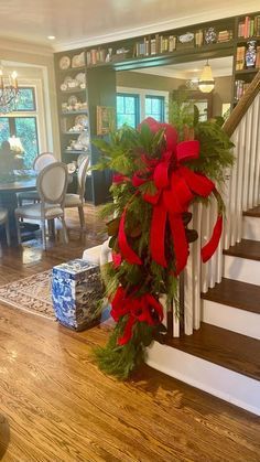 a christmas wreath is on the banister at the bottom of stairs in a living room