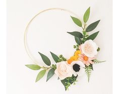 an image of flowers arranged in a circle on a white background with greenery around it