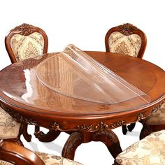 a wooden table with chairs and a clear plastic cover on it