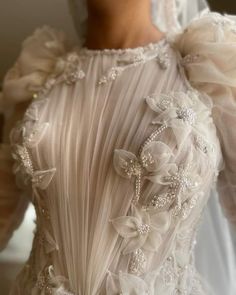 the back of a wedding dress with flowers on it