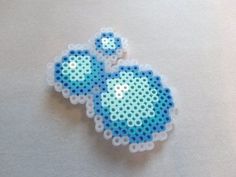 two pieces of blue and white beaded broochies on top of a table