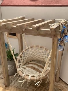 a hammock hanging from a wooden frame on a shelf next to a potted plant