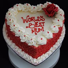 a heart shaped cake with the words world's best mum written on it and a red rose