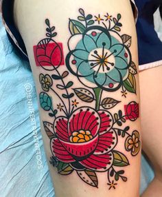 a woman's thigh with flowers and leaves on it