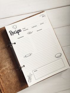 a recipe book sitting on top of a wooden cutting board