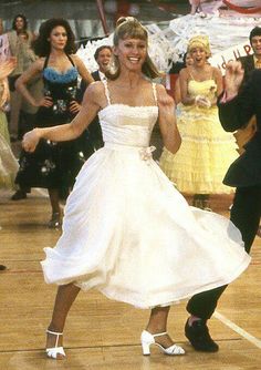 a man and woman dancing on a dance floor with other people in costume behind them