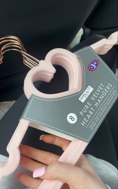 a person holding a pink heart shaped bottle opener in their hand with the tag attached to it