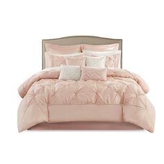 a bed with pink comforters and pillows