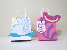 two paper bags with tags on them are sitting next to each other, one has a face and the other has a mouth