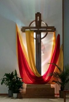 the cross is decorated with red and yellow drapes