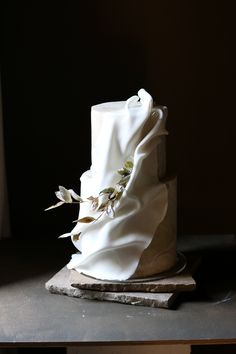 a three tiered white wedding cake sitting on top of a table