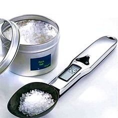 a measuring spoon with sugar in it next to a canister filled with white sugar