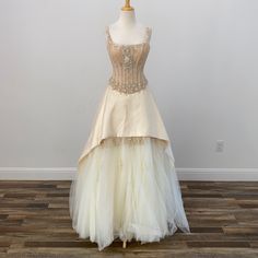 a dress on a mannequin in front of a white wall and wooden floor