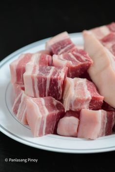 pieces of raw meat on a white plate