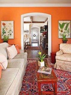 an orange living room with two couches and a coffee table in the center area