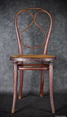 a wooden chair with a woven seat pad on it's back and sides, against a gray background