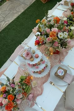 a long table with plates and flowers on it