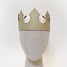 a white mannequin head with a crown on it