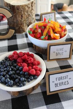 a table topped with bowls filled with fruit and veggies on top of a black and white checkered table cloth