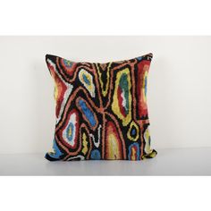 a colorful pillow on a white surface