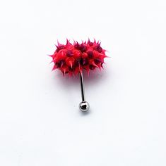 a metal ball with spikes on it sitting on a white surface next to a silver object