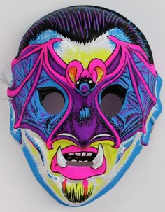 a colorful mask is hanging on the wall