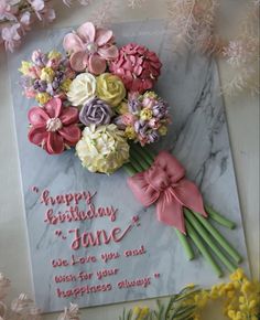 a bouquet of flowers sitting on top of a marble slab with the words happy birthday june