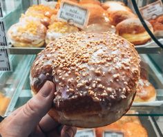 a person holding up a donut with chocolate icing and sprinkles