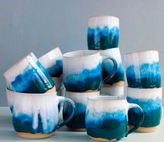 blue and white coffee mugs stacked on top of each other