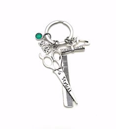 a silver key chain with a green stone on it's center and the words crazy hair