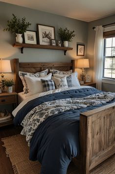 a bed with blue comforter and pillows in a bedroom next to a window,