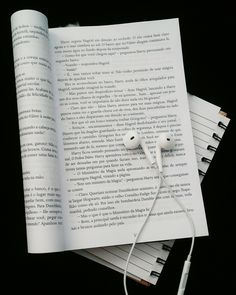 an open book with earphones on top of it